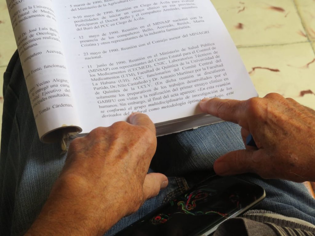 Nilo Castañedo hojea el libro "Sueños convertidos en realidad", de su autoría, mientras evoca anécdotas y enseñanzas de Fidel